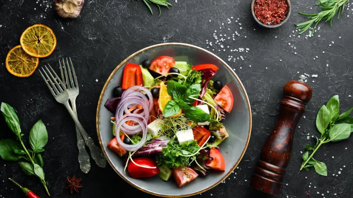 Färgglad sallad med grönsaker och rödlök i en skål